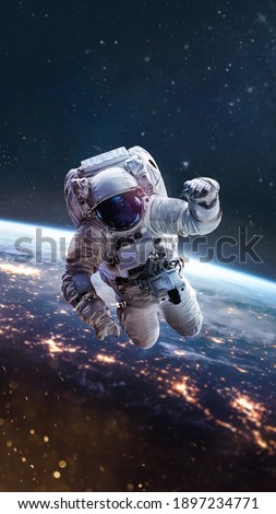 Astronaut fly in outer space on orbit of Earth planet. Night. City lights. Spaceman in spacesuit. Elements of this image furnished by NASA.