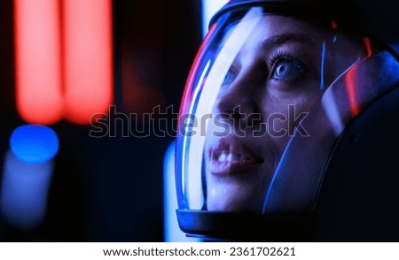 Astronaut in futuristic costume. Girl in glasses of virtual reality while touching air. Augmented reality game, future technology, AI concept. Dark background.