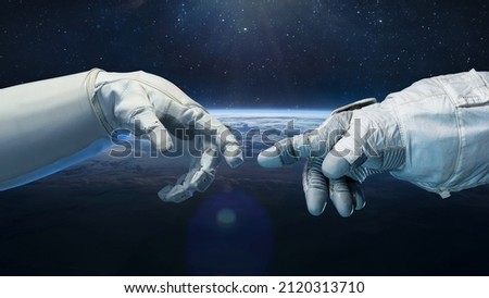 Astronaut in glove and robot hands in space. Earth planet on background. Technology and space flight. Elements of this image furnished by NASA 