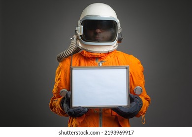 Astronaut holding in hand a blank diploma certificate with copy space. Space message. Space program goals tempalte. - Shutterstock ID 2193969917