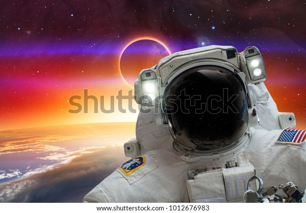 An astronaut\
making selfie over Earth background against Solar eclipse\
\