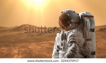 AStronaut on surface of Mars. Spaceman walk on red planet. Mars planet expedition. Elements of this image furnished by NASA