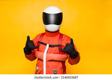 Astronaut With Orange Spacesuit On Yellow Background 
Waving