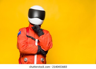 Astronaut With Orange Spacesuit With Thoughtful Gesture On Yellow Background