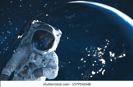 Astronaut in outer space against the backdrop of the planet earth. Elements of this image furnished by NASA.	