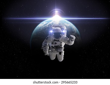 Astronaut in outer space against the backdrop of the planet earth. Elements of this image furnished by NASA.
