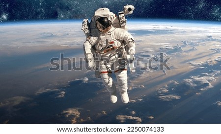 Astronaut in outer space against the backdrop of the planet earth. Elements of this image furnished by NASA.