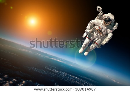 Astronaut in outer space against the backdrop of the planet earth. Elements of this image furnished by NASA.