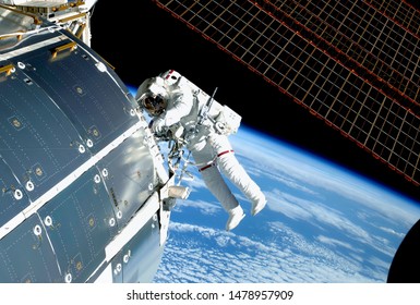 The Astronaut In An Outer Space, At The ISS, Repairs And Makes Experiments. Elements Of This Image Were Furnished By NASA