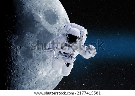 Astronaut in outer space on a background of moon. National Moon Day. Conceptual image. Elements of this image furnished by NASA.