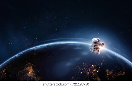 Astronaut in outer space over of the planet earth at the night hemisphere. Science theme. Astronomy concept. Elements of this image furnished by NASA.