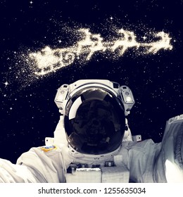 Astronaut in outer space with santa flying over stars sky. Elements of this image furnished by NASA