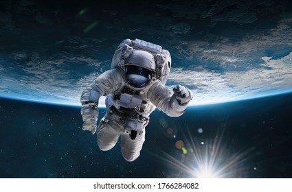 Astronaut In The Outer Space With Sun Over The Planet Earth. Abstract Wallpaper. Spaceman. Elements Of This Image Furnished By NASA
