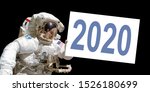 Astronaut in space holding a 2020 white  board - New year greeting card - elements of this image are provided by NASA