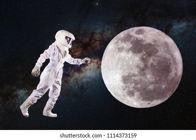 Astronaut In Space And Moon Exploration. Concept, Astronaut Pulls His Hand To The Lunar Surface. Elements Of This Image Furnished By NASA.