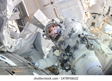 The Astronaut In A Space Suit, In The ISS, Lasts A Hand In The Camera. Elements Of This Image Were Furnished By NASA