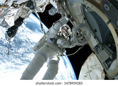 The astronaut in a space suit, in an outer space, is engaged in repair of the space station. Elements of this image were furnished by NASA