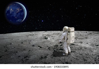 An astronaut standing on the surface of the moon looking up to the earth on the background. Elements of this image furnished by NASA. - Shutterstock ID 1908333895