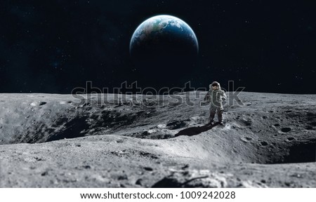 Astronaut stay on the Moon surface against Earth on the background, Exploring space and other planets