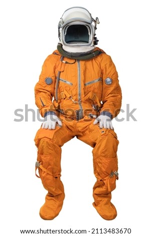 Astronaut wearing an orange spacesuit and open space helmet sitting isolated on white background. Unrecognizable cosmonaut isolated on white background