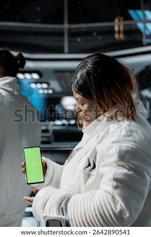 Astronauts doing tests using mockup smartphone aboard high tech starship during spaceflight. Space station crew members using green screen mobile phone to do systems analysis