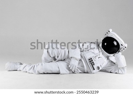 Astronauts lying on its side, white background