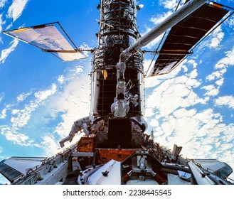 Astronauts servicing the Hubble telescope in space. Planet earth seen in the background. Digitally enhanced. Elements of this image furnished by NASA.   - Powered by Shutterstock