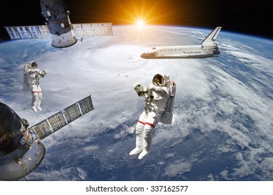 Astronauts, space shuttle and station in outer space - Elements of this image furnished by NASA - Powered by Shutterstock