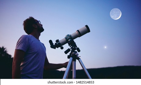 Astronomer with a telescope watching at the stars and Moon. 