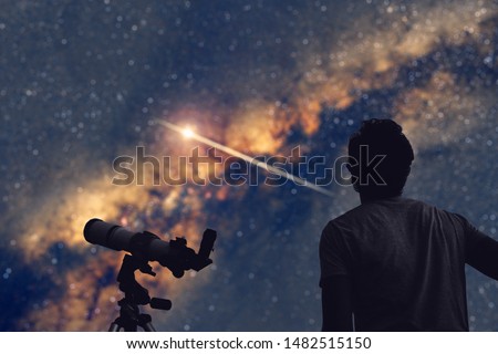 Astronomer with a telescope watching at the stars and Moon. 