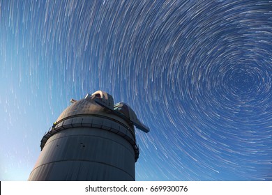 Astronomical observatory under the night sky stars. Blue sky with hundreds of stars of the Milky way. Timelapse in comet mode.