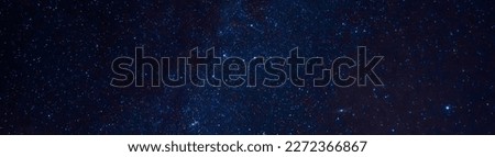 Astrophotography of a dark blue starry sky with many stars, nebulae and galaxies. Panoramic wide horizontal photo for banner head cover