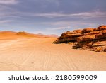 Atacama desert in Chile with tire tracks leading to horizon and interesting orange rocks