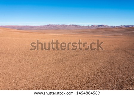Atacama Desert vast dry extensions in the driest area of this amazing desert Just sand, rocks and car tracks remains on this old dry ground surface with no life at sight up to the far infinite horizon