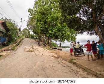 Atalaia do Norte, Brazil - Sep 2019: Asphalt road and huge trees in a village on the banks of the Javari River (Amazonka tributary) in the Javari Valley - Amazon rain forest. Amazonia. Latin America