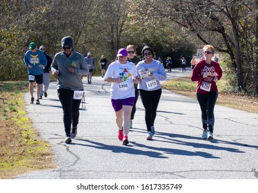 Athens, Georgia - January 1, 2020: A group of smiling runners takes a turn during New Years at Noon 5k road race.