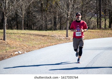 Athens, Georgia - January 1, 2020: A Man Runs Alone During The New Years At Noon 5k Road Race.