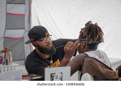 Athens, Georgia - June 22, 2019: An Artist Applies Facepaint To A Young Girl's Face In A Booth In The KidsFest Area At The AthFest Music And Arts Festival.