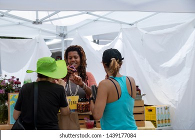 Athens, Georgia - June 22, 2019: A Vendor In The Artist Market Area Takes A Mobile Payment From A Customer During The AthFest Music And Arts Festival.