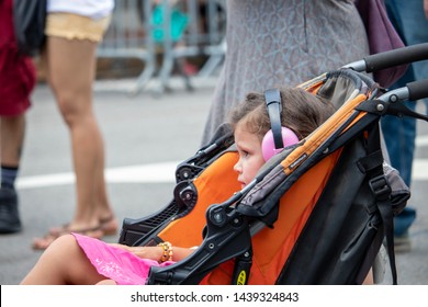 Athens, Georgia - June 22, 2019: A Young Girl In A Stroller Wears Hearing Protection While Listening To A Live Music Performance At The AthFest Music And Arts Festival.