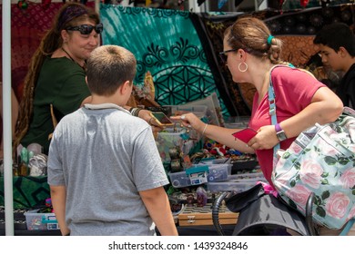 Athens, Georgia - June 22, 2019: A Vendor At A Market Stall Takes A Mobile Payment From A Customer During The AthFest Music And Arts Festival.