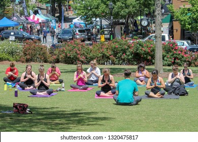 ATHENS, GEORGIA, U.S.A. – April 27, 2018: UGA Students Take A Yoga Class On The North Campus Lawn On A Beautiful Spring Afternoon As The Twilight Criterium Expo Takes Place On Downtown College Avenue.