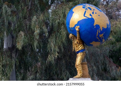 Athens , Greece - 27.03.2022: Street performer as the Titan Atlas holding the globe on his shoulders. 