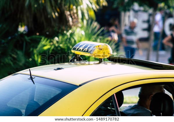 Athens Greece\
August 27, 2019 View of Greek yellow taxi rolling through the\
streets of Athens in the\
morning\
