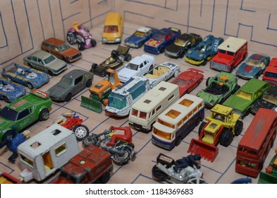 Athens, Greece – December 15, 2016: Old Matchbox Toy Cars Of The 70’s, Parked On A Wooden Deck With The Pattern Of A Labyrinth, Designed With A Blue Pen.