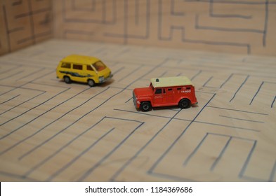 Athens, Greece – December 15, 2016: Old Matchbox Toy Cars Of The 70’s, Parked On A Wooden Deck With The Pattern Of A Labyrinth, Designed With A Blue Pen.