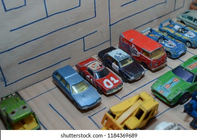 Athens, Greece – December 15, 2016: Old Matchbox Toy Cars Of The 70’s, Parked On A Wooden Deck With The Pattern Of A Labyrinth, Designed With A Blue Pen.