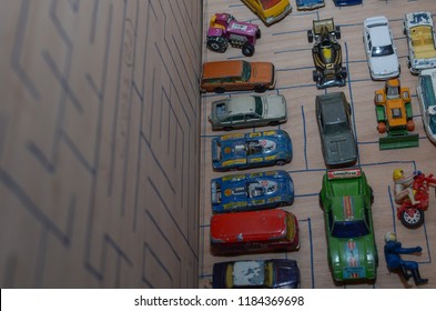 Athens, Greece – December 15, 2016: Old Matchbox Toy Cars Of The 70’s, Parked On A Wooden Deck With The Pattern Of A Labyrinth, Designed With A Blue Pen.