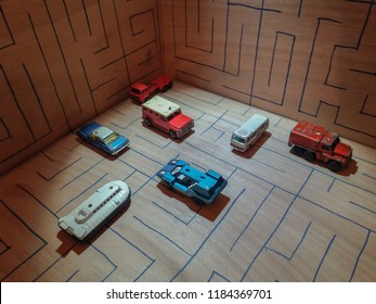 Athens, Greece – December 15, 2016: Old Matchbox Toy Cars Of The 70’s, Parked On A Wooden Deck With The Pattern Of A Labyrinth, Designed With A Blue Pen.