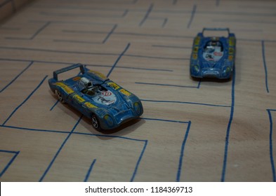 Athens, Greece – December 15, 2016: Old Matchbox Toy Cars Of The 70’s, Parked On A Wooden Deck With The Pattern Of A Labyrinth, Designed With A Blue Pen.